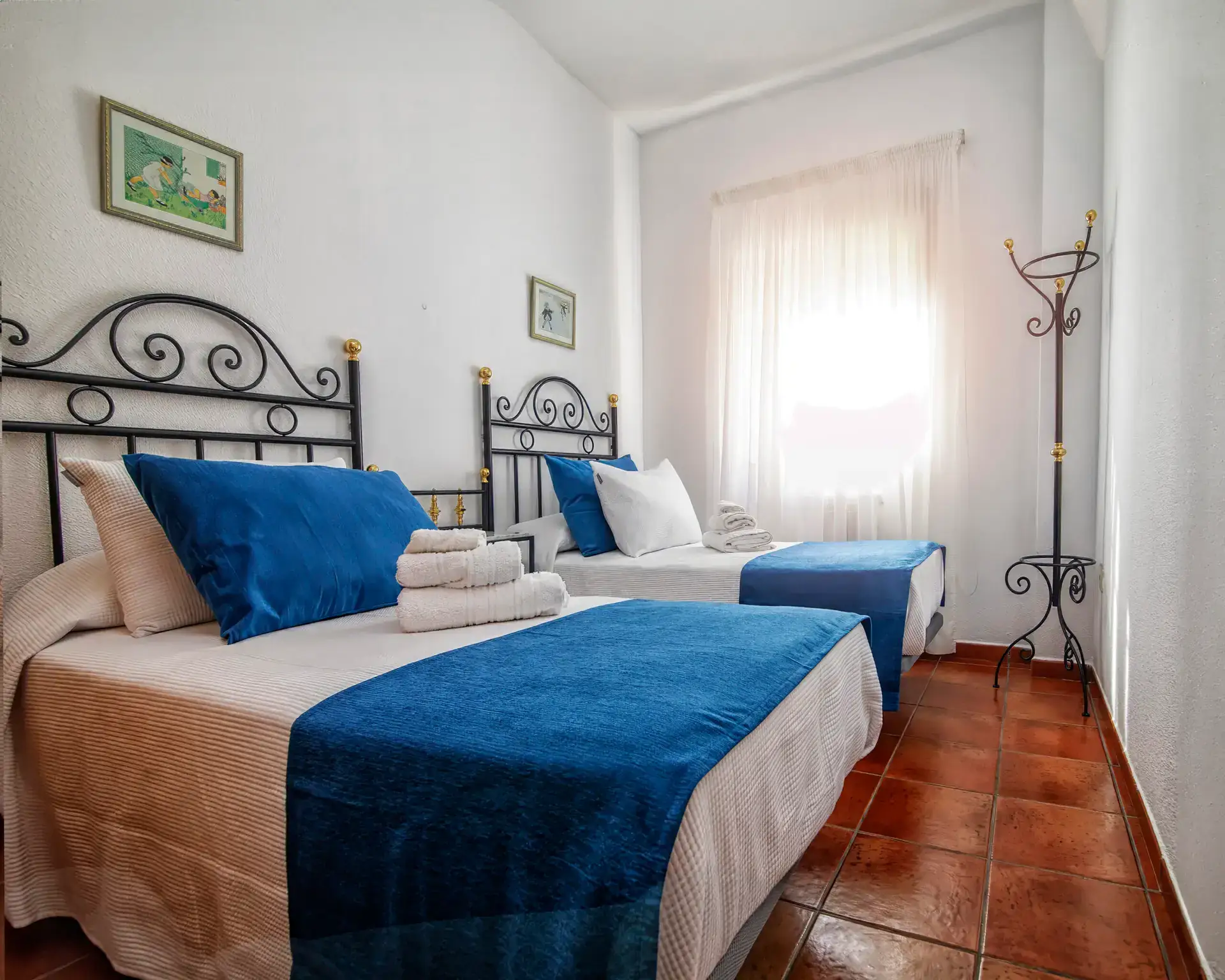 Dormitorio con dos camas individuales y cabecero de forja