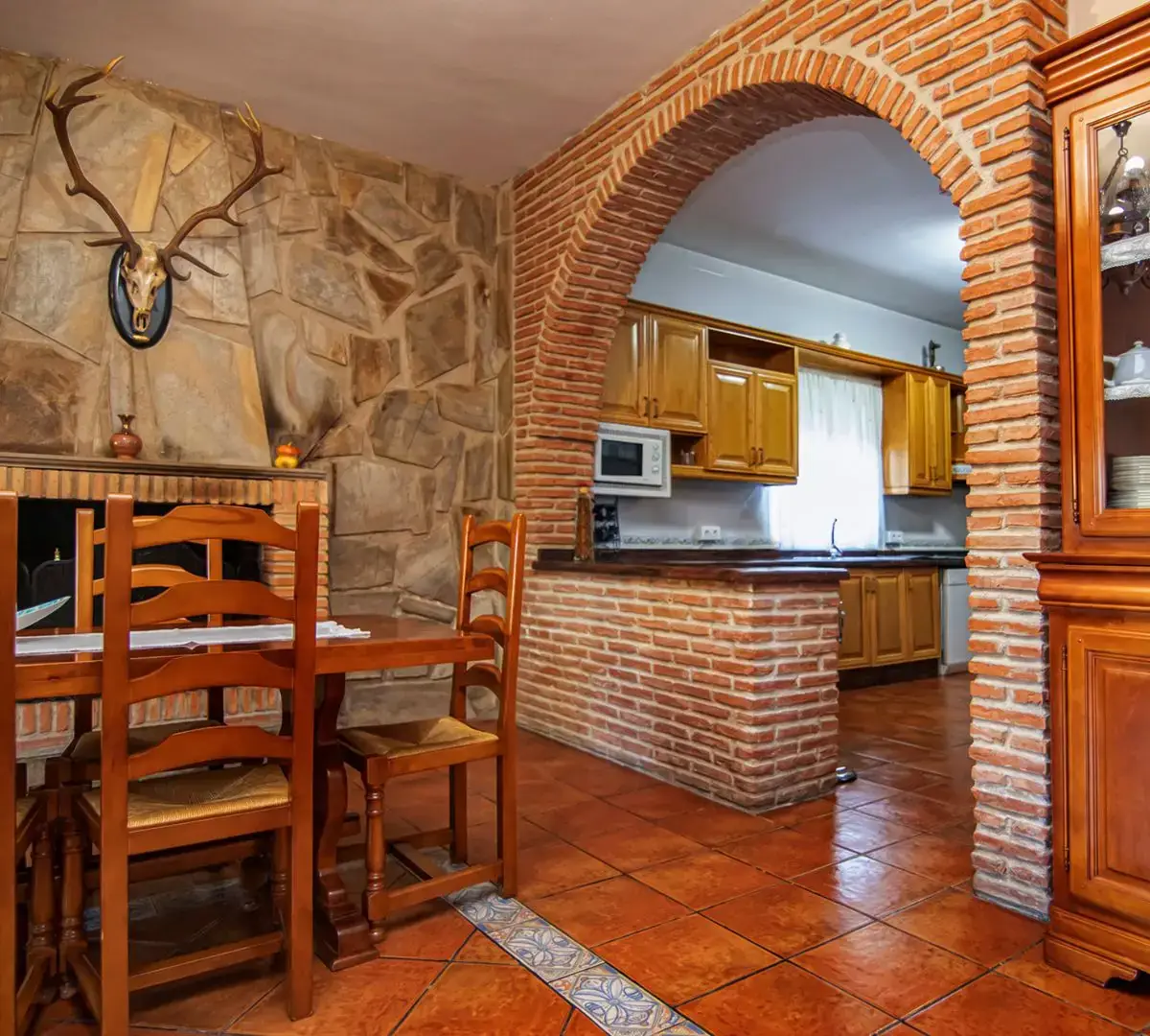 Cocina con arco de piedra y barra de desayuno