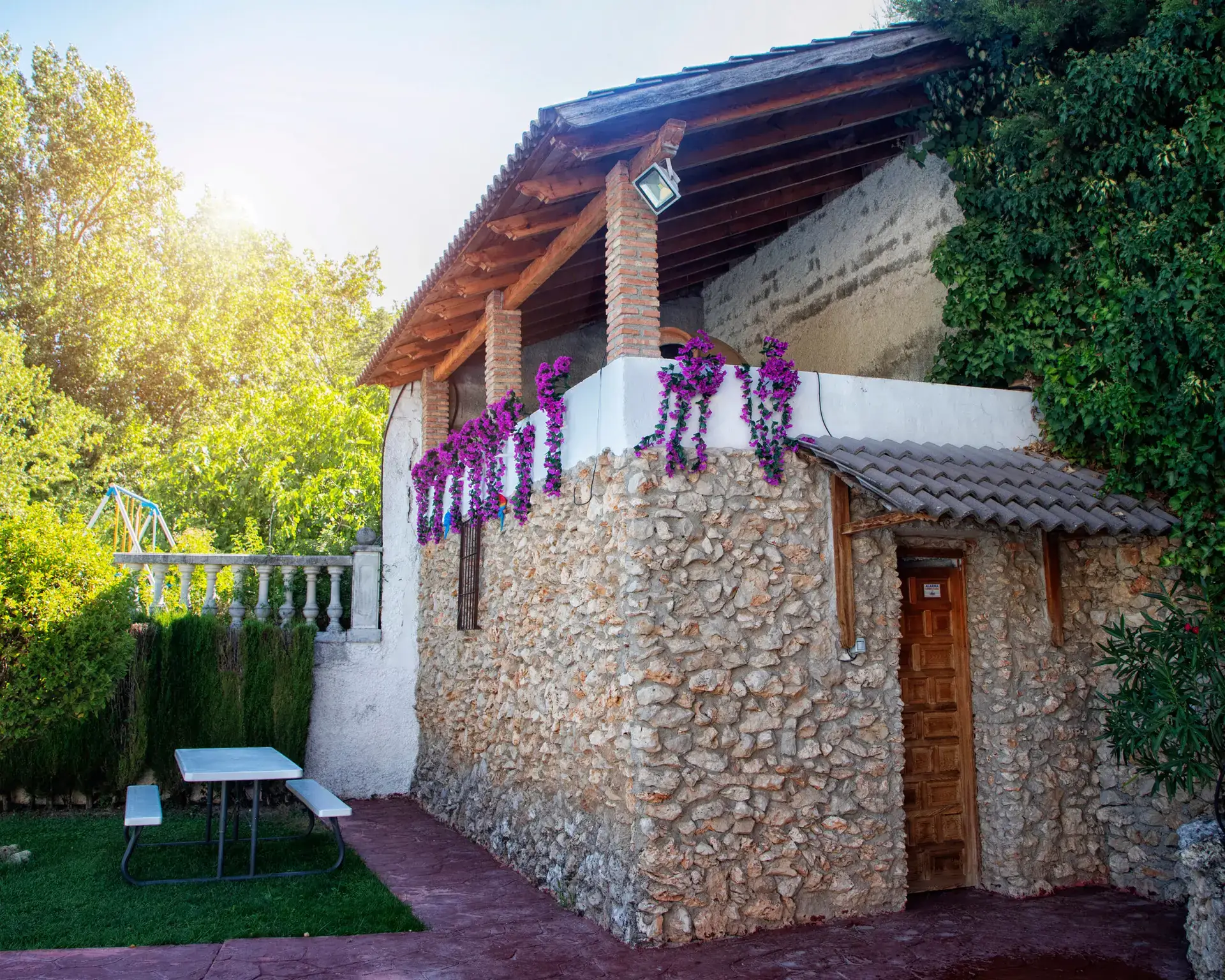 Fachada de piedra con buganvilla en flor