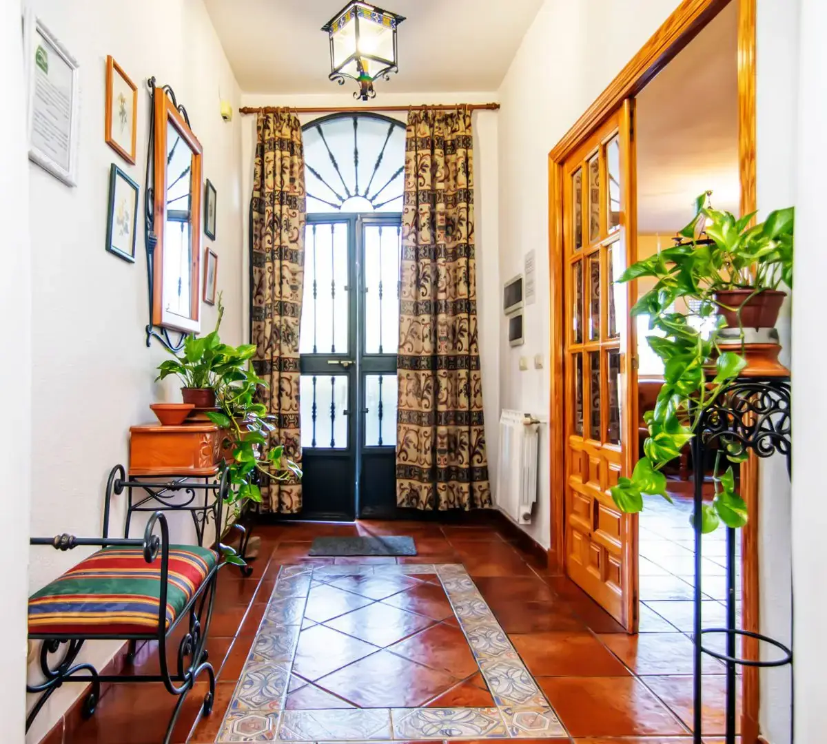 Recibidor con puertas de madera y suelo de mosaico