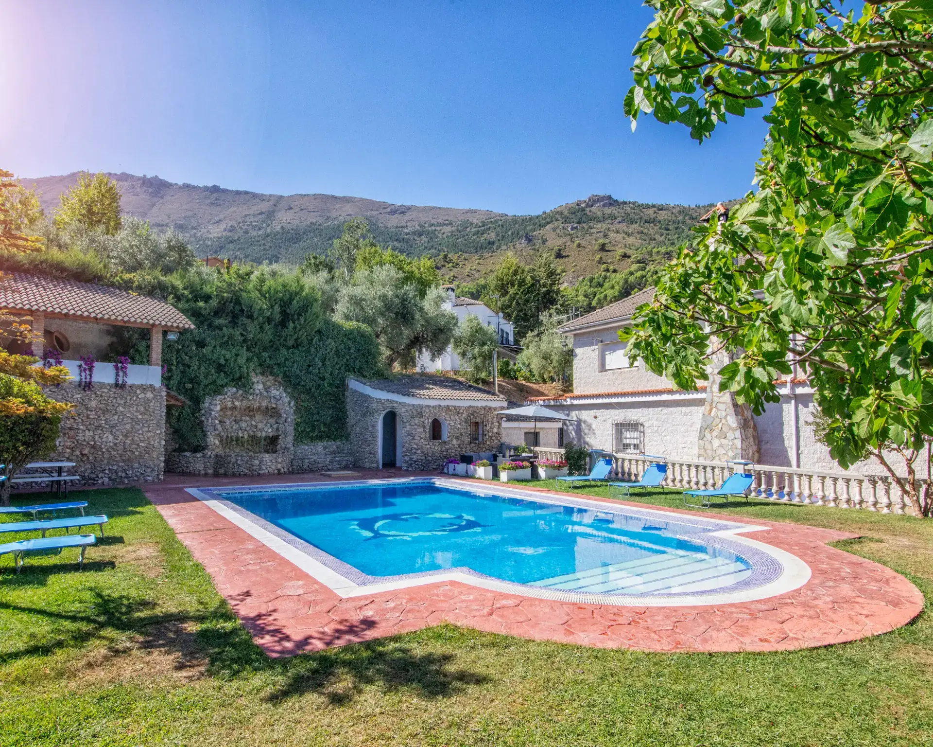 Piscina privada con tumbonas y la sierra al fondo